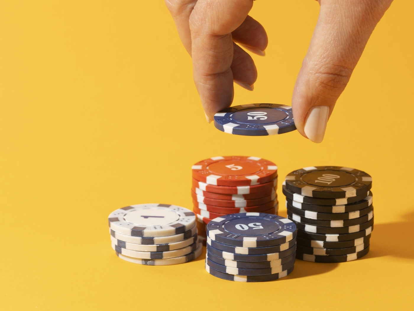 Фишки для казино с рукой на желтом фоне