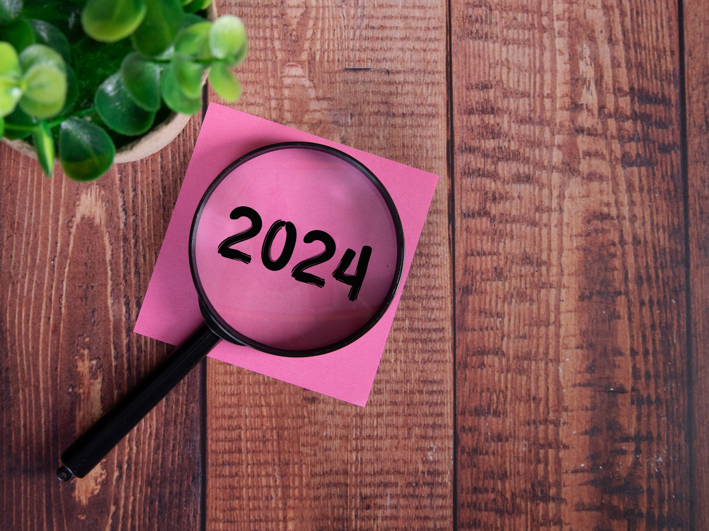 Увеличительное стекло с листом бумаги и цветком на столе