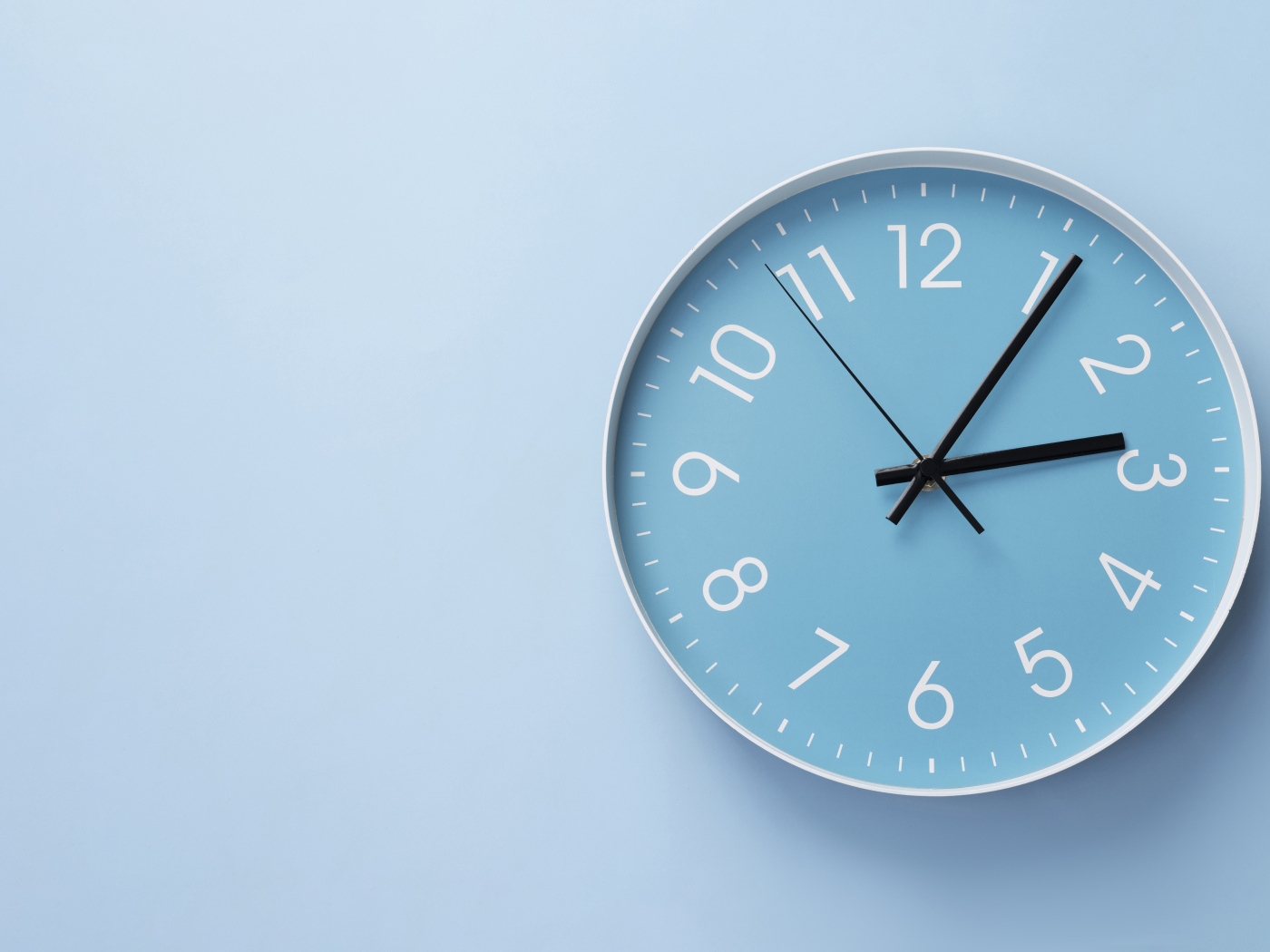 Круглые часы на голубом фоне крупным планом