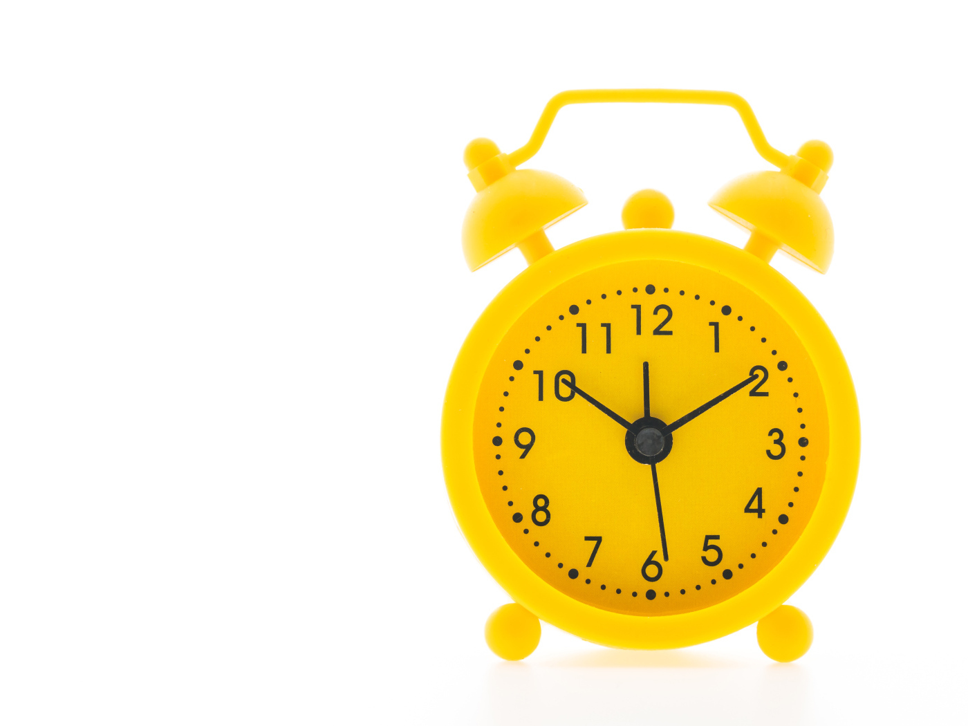 Желтый будильник на белом фоне