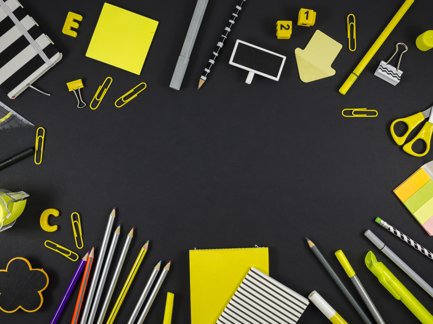 Желтые разные канцелярские предметы на черной поверхности 