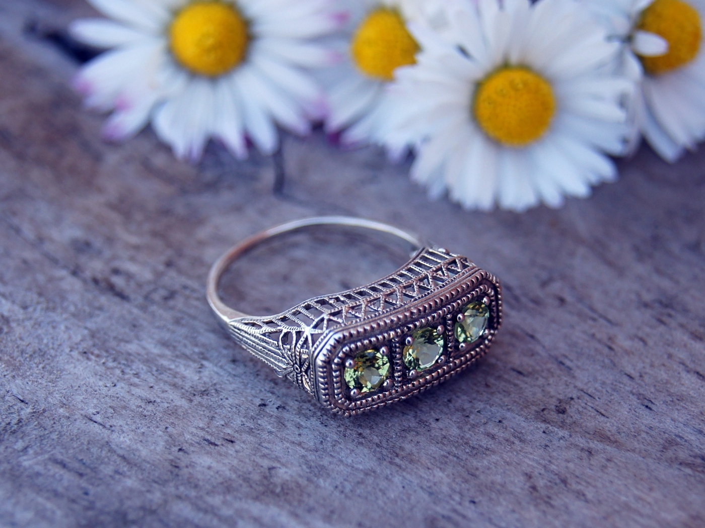 Старинный перстень на столе с ромашками