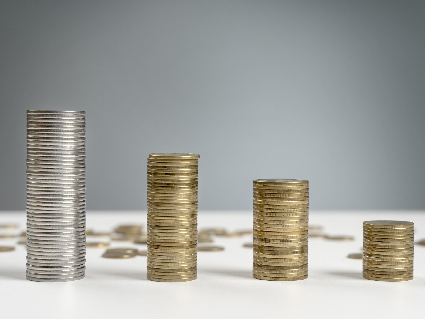 Стопки монет на сером фоне на столе