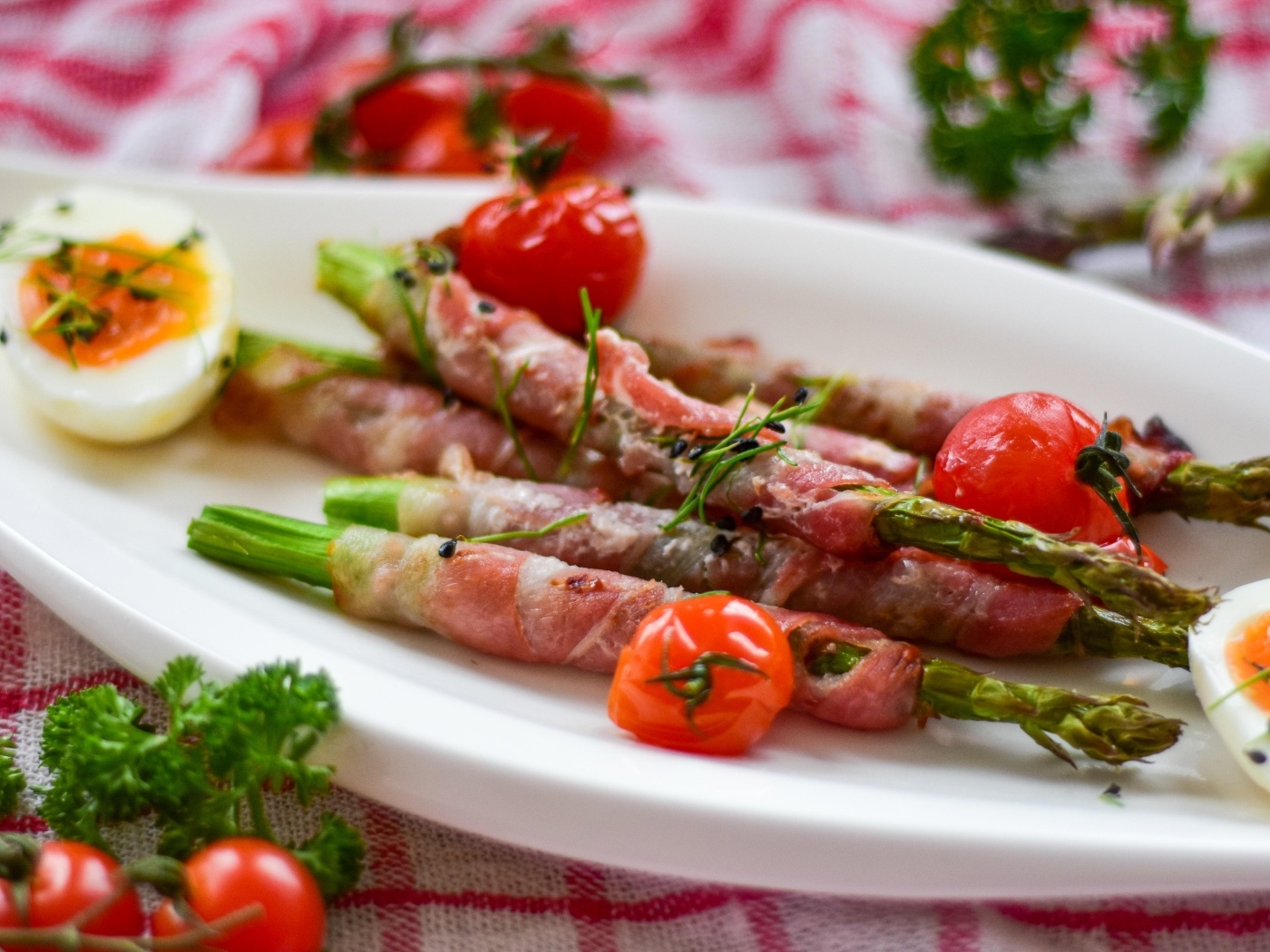 Спаржа в беконе на тарелке с вареными яйцами