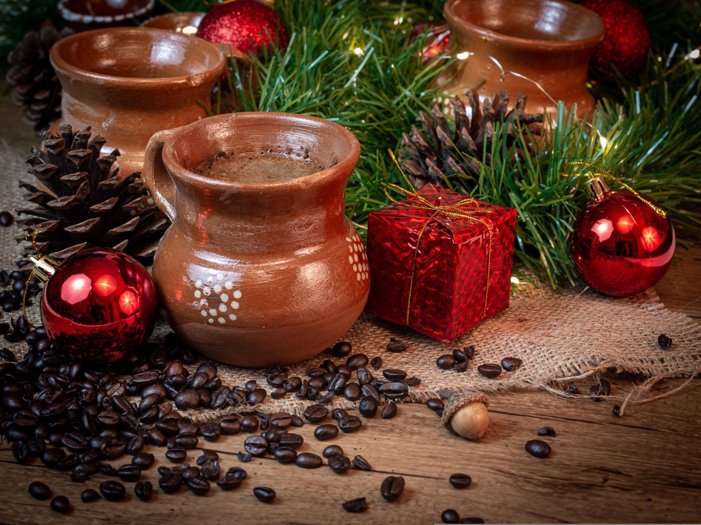 Кофейные зерна на столе с посудой и еловой веткой