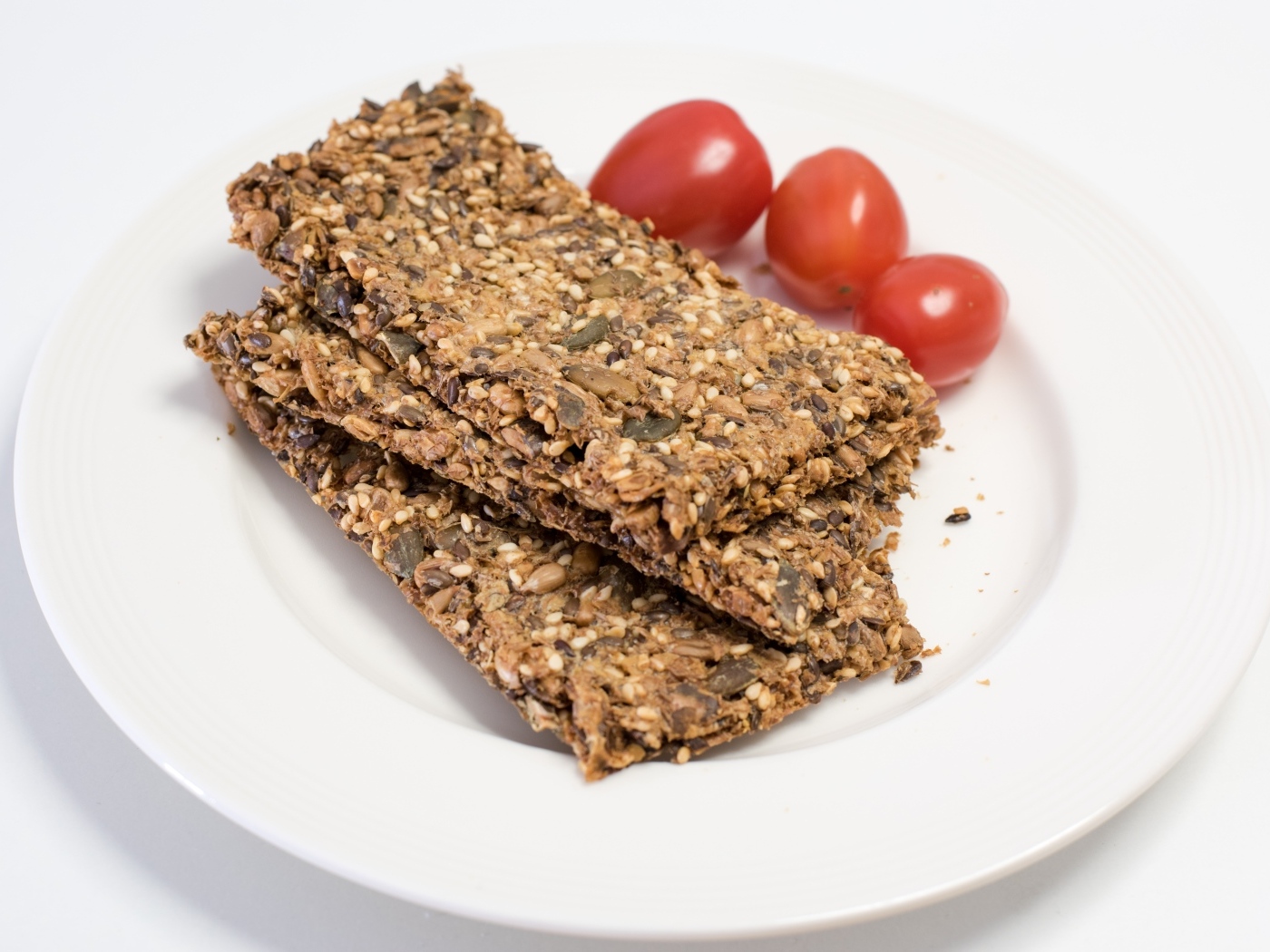 Полезны злаковые хлебцы на тарелке с помидорами