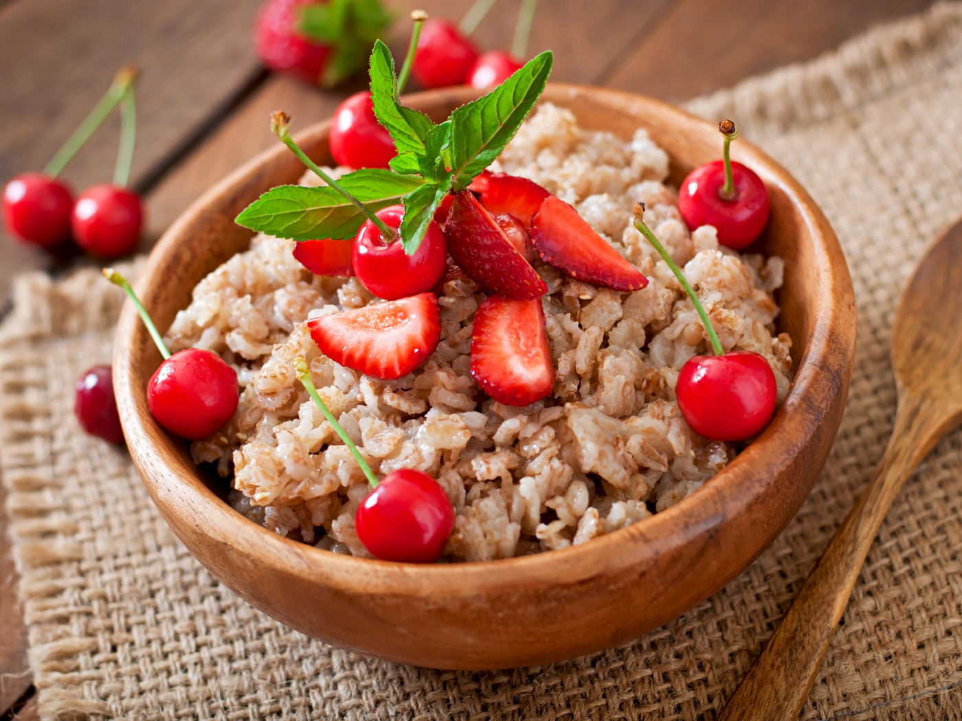 Овсяная каша с ягодами в деревянной миске