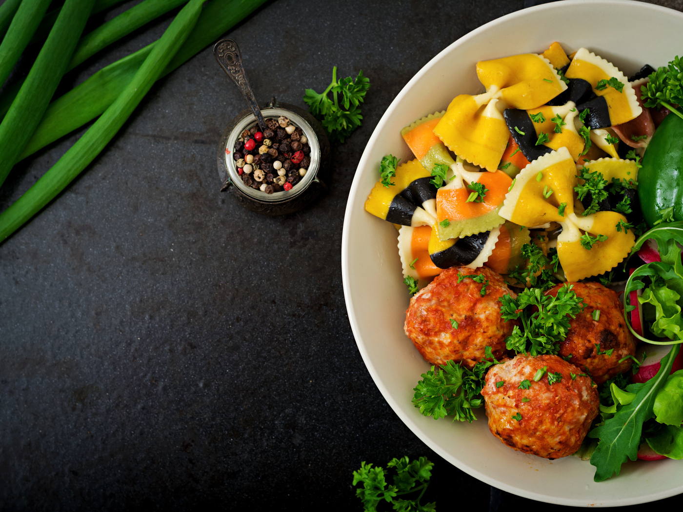 Паста с тефтелями и салатом в тарелке