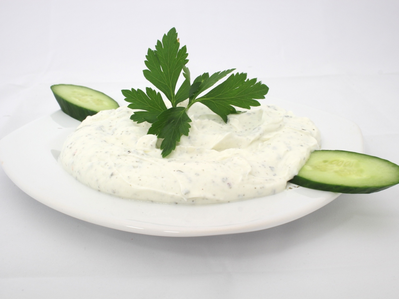 Соус на тарелке со свежими огурцами