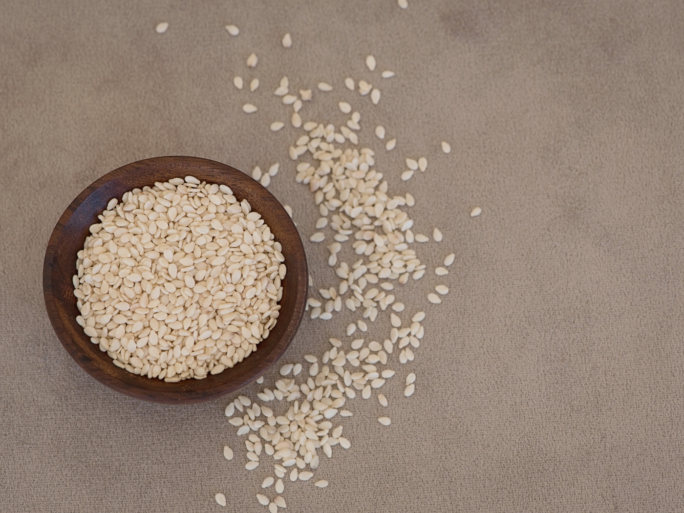 Зерна кунжута в деревянной миске на столе