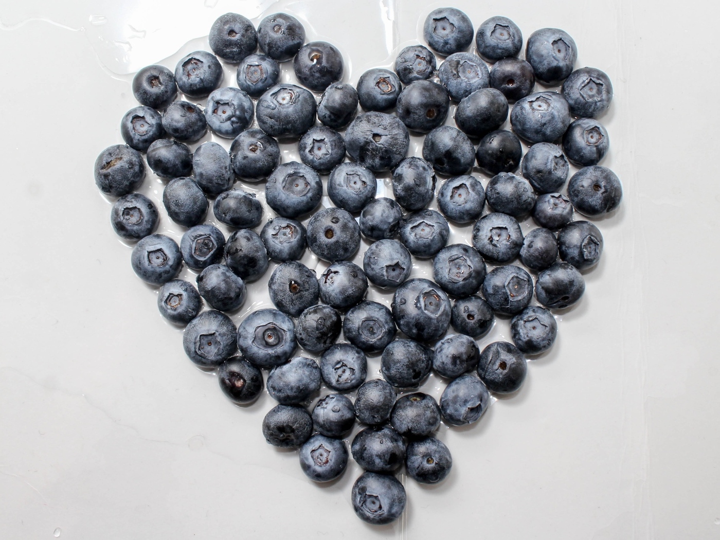 Сердце из ягод черники на сером столе