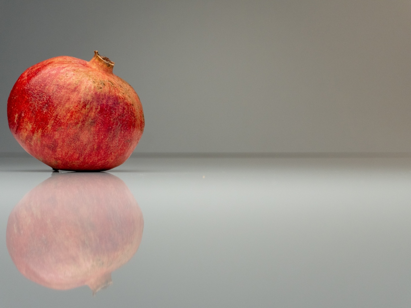 Красный гранат отражается в серой зеркальной поверхности