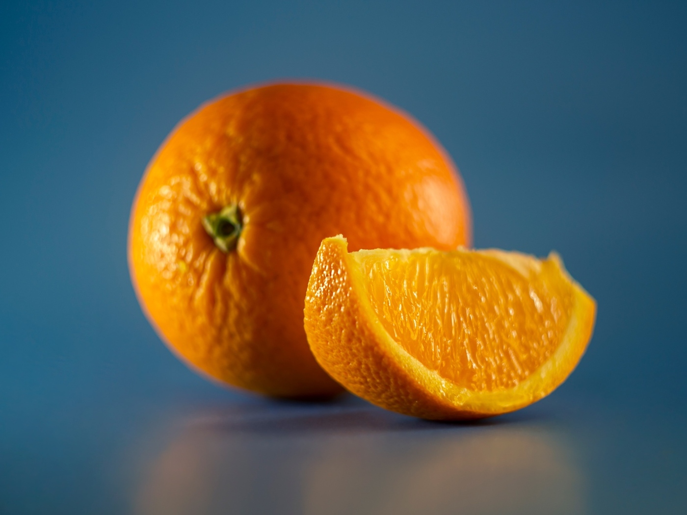 Спелый оранжевый апельсин на голубом фоне