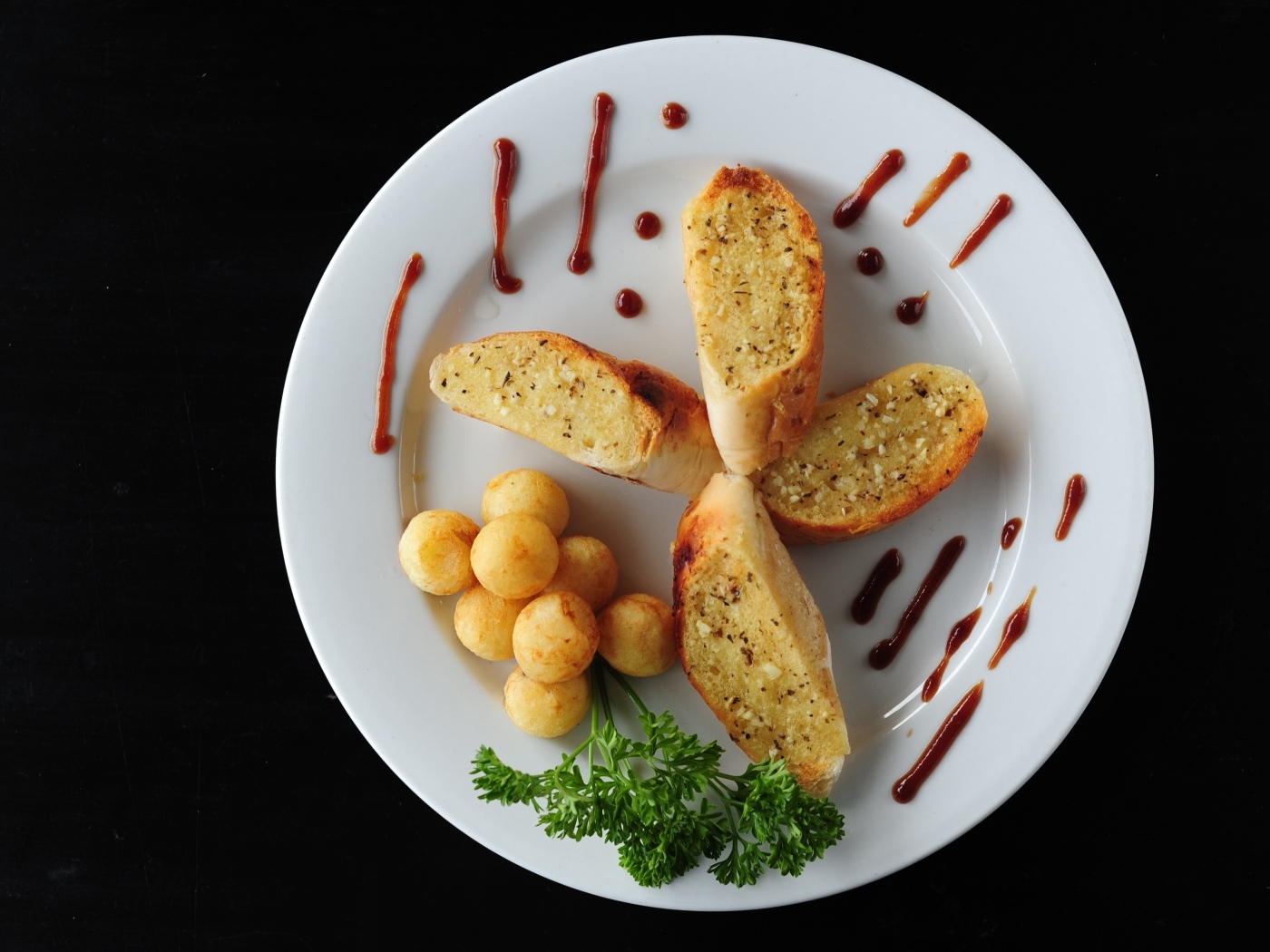 Чесночный хлеб на тарелке с картофельными шариками