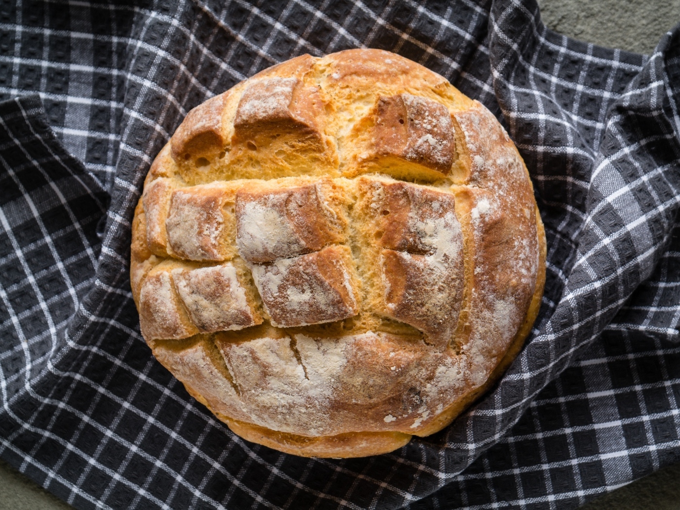 Круглый хрустящий хлеб на столе со скатертью