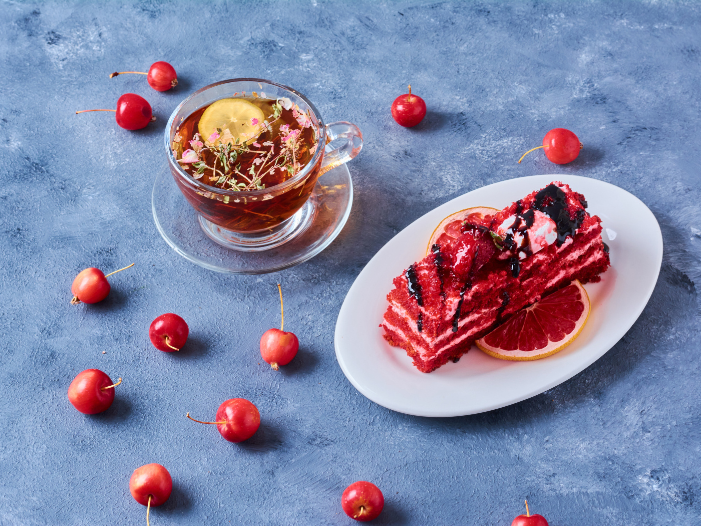 Аппетитный кусок торта на столе с чаем и ягодами черешни