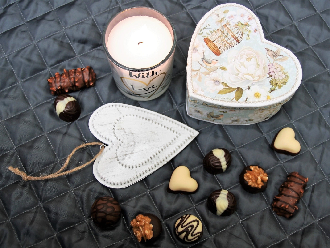 Коробка на кровати с конфетами и свечой