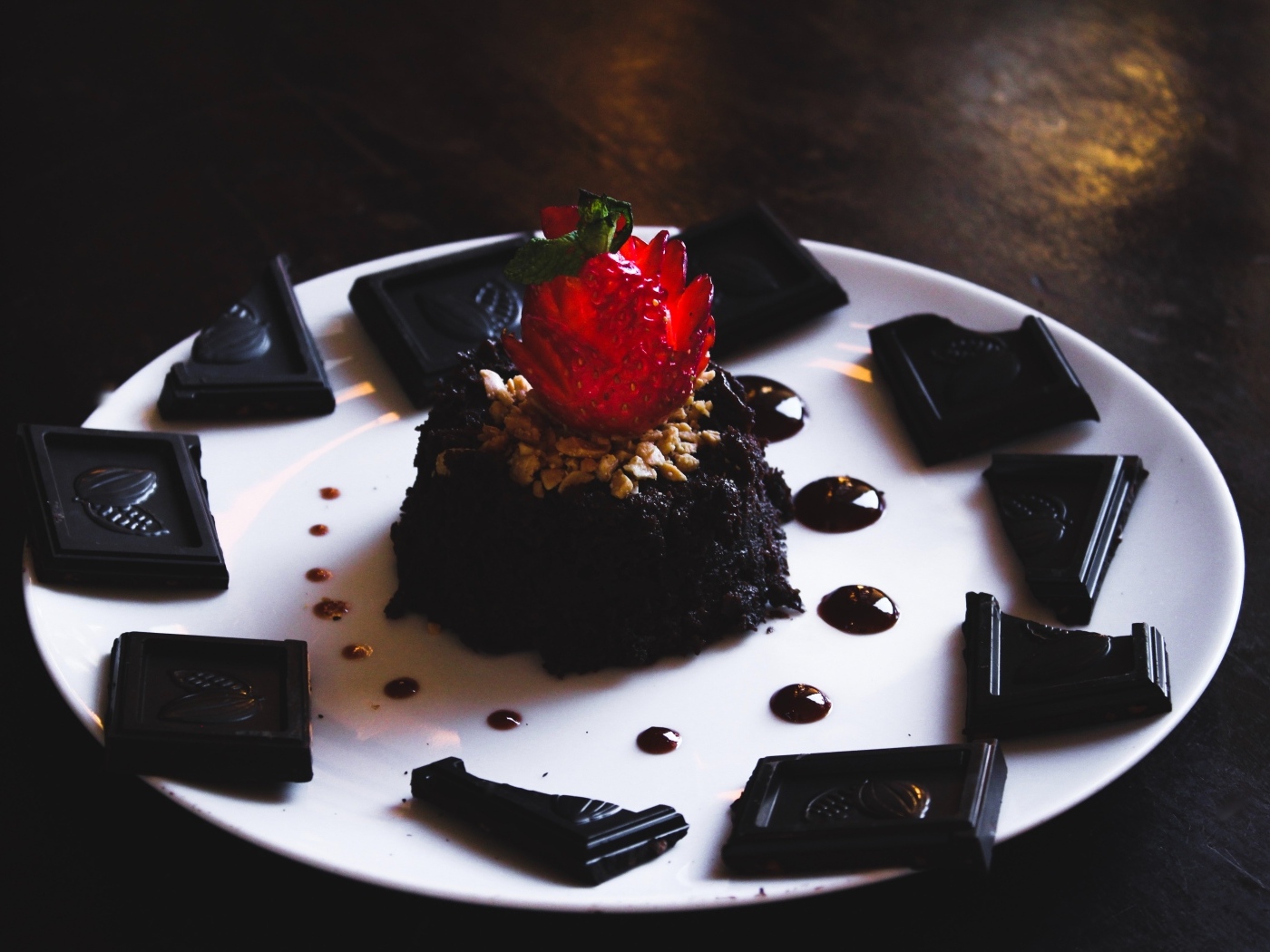 Десерт брауни на большой белой тарелке с шоколадом