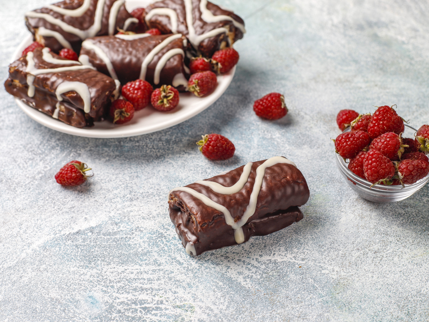 Шоколадные рулетики с ягодами малины на столе