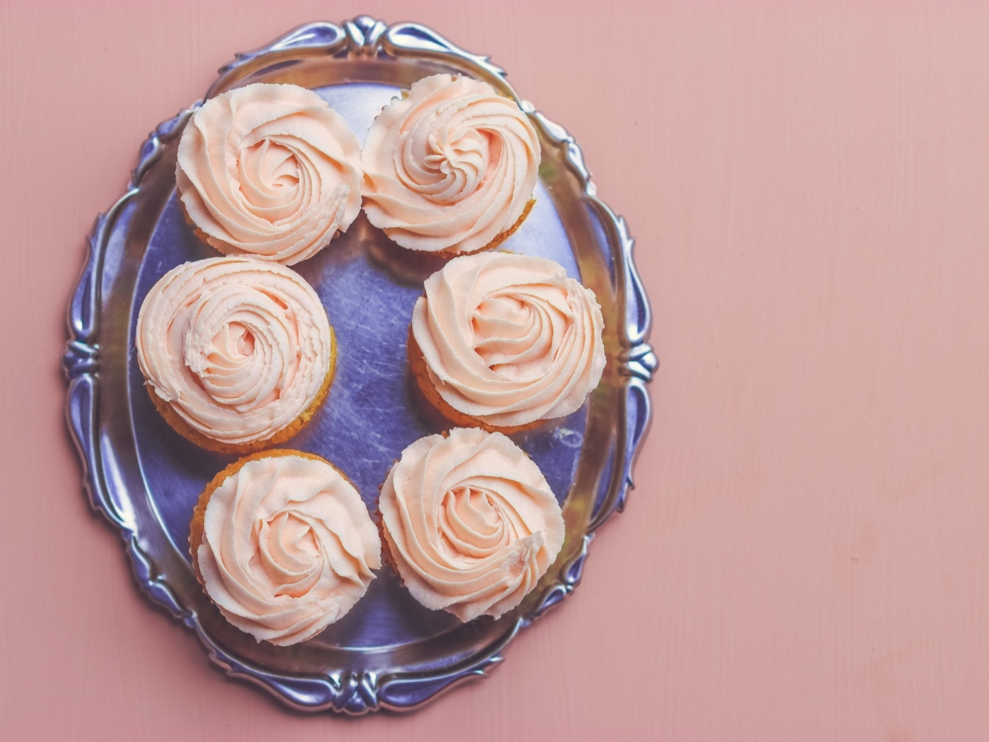 Кексы с розовым кремом на столе