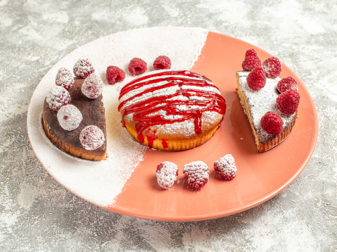 Десерт с ягодами малины и сахарной пудрой на большой тарелке