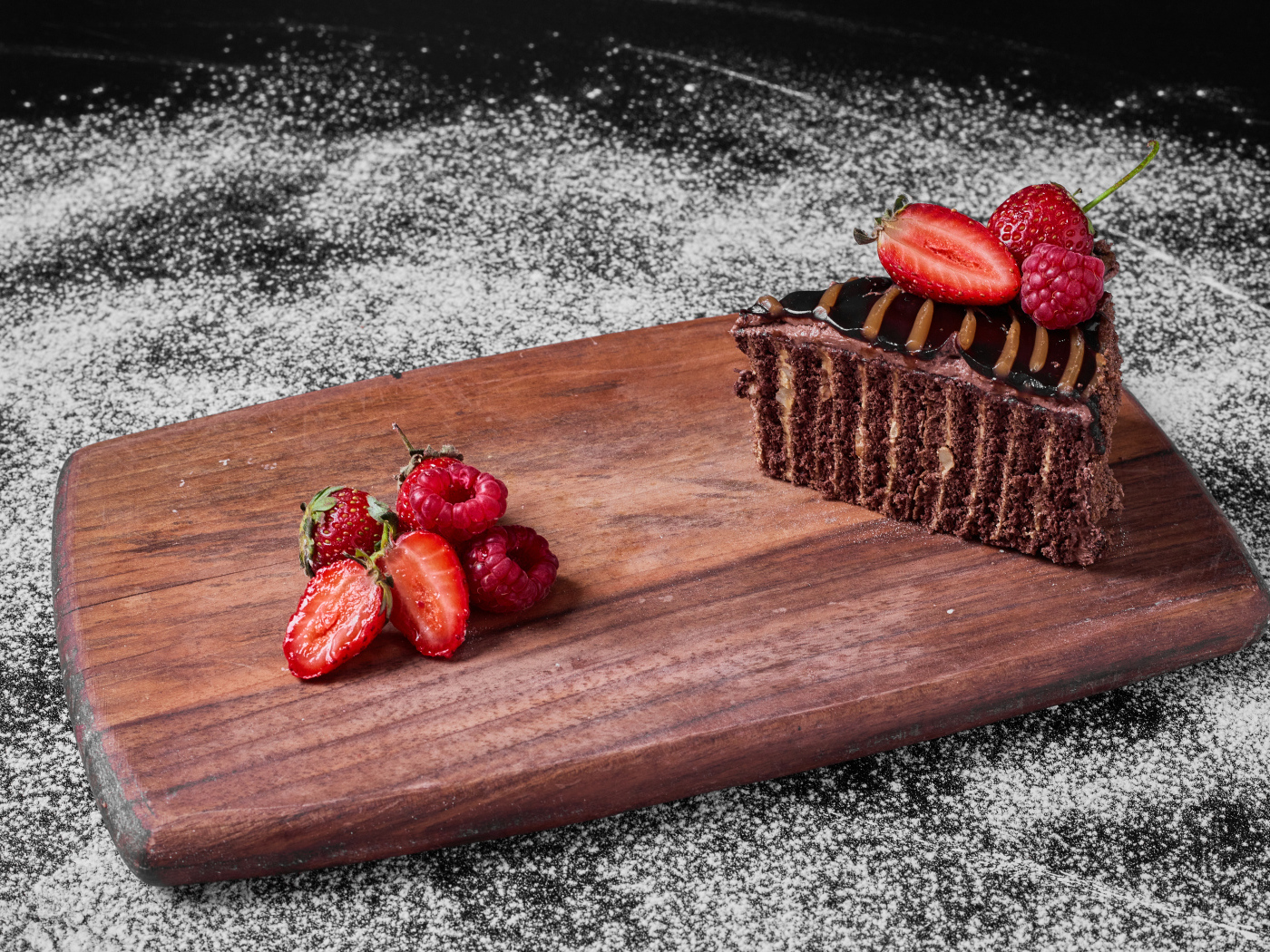 Кусок торта брауни с ягодами на доске