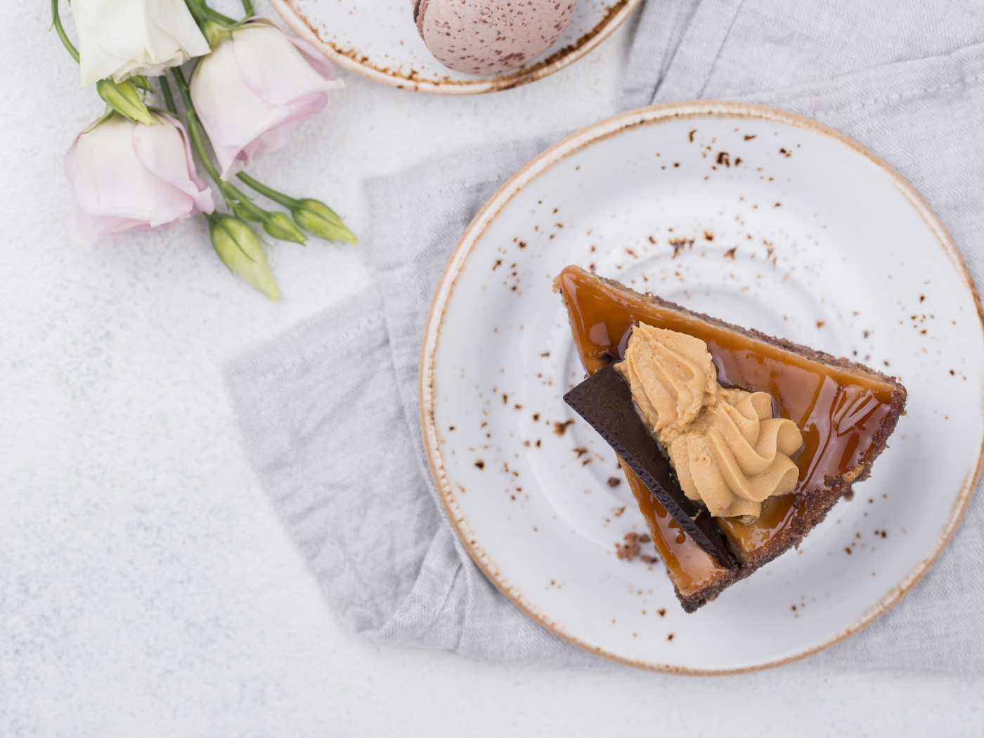 Кусок торта на тарелке на столе с цветами