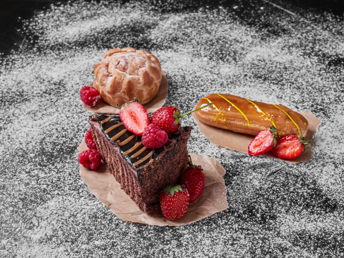 Кусок торта с ягодами на столе с эклером