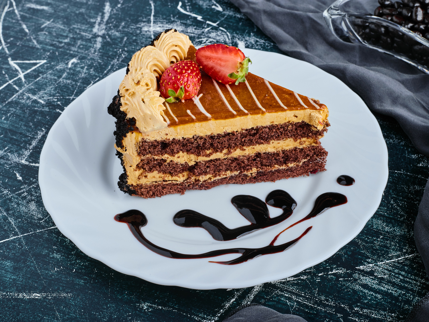 Кусок торта с клубникой на большой белой тарелке