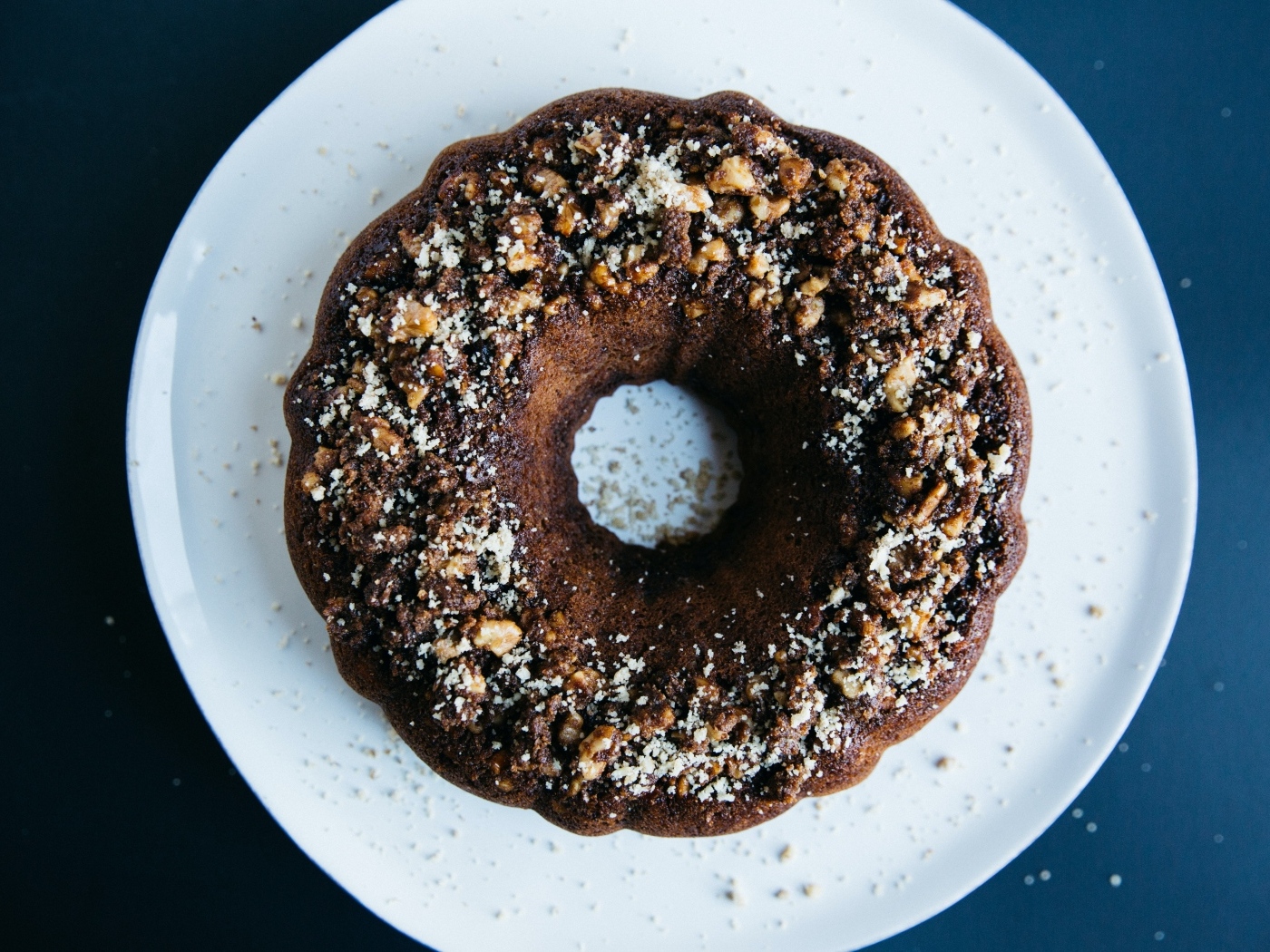 Круглый шоколадный кекс на большой белой тарелке