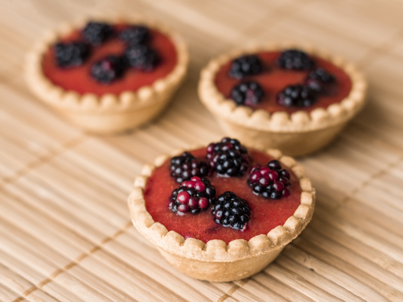 Три пирожных с ягодами и кремом