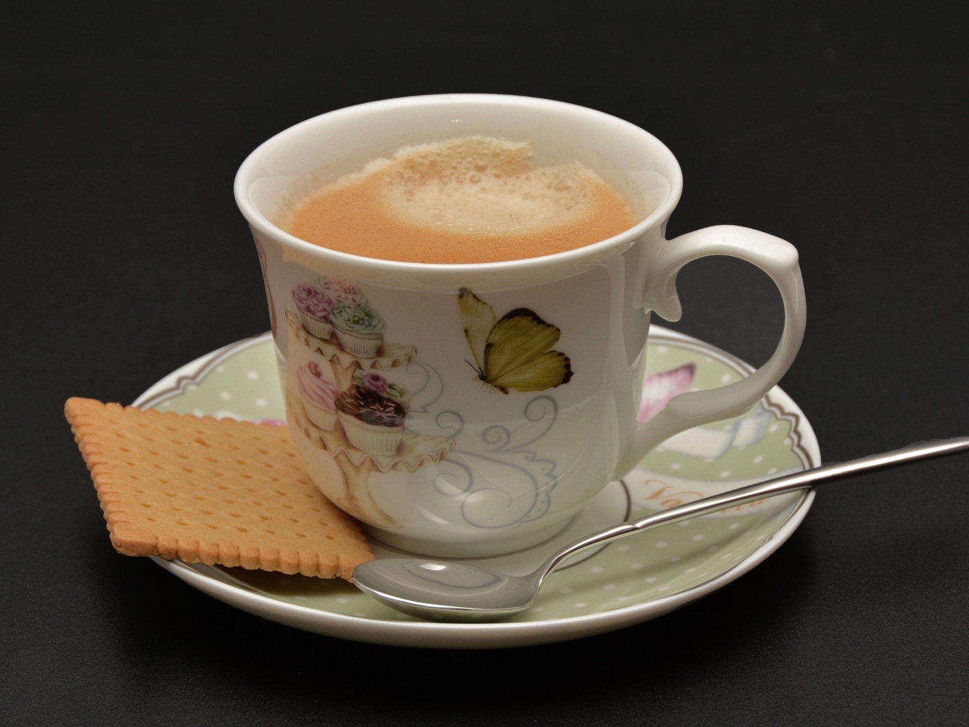 Чашка какао с печеньем на сером фоне