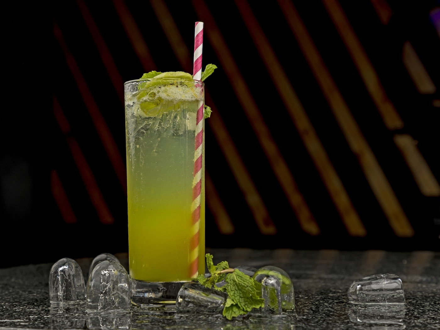 Зеленый коктейль мохито в высоком стакане со льдом
