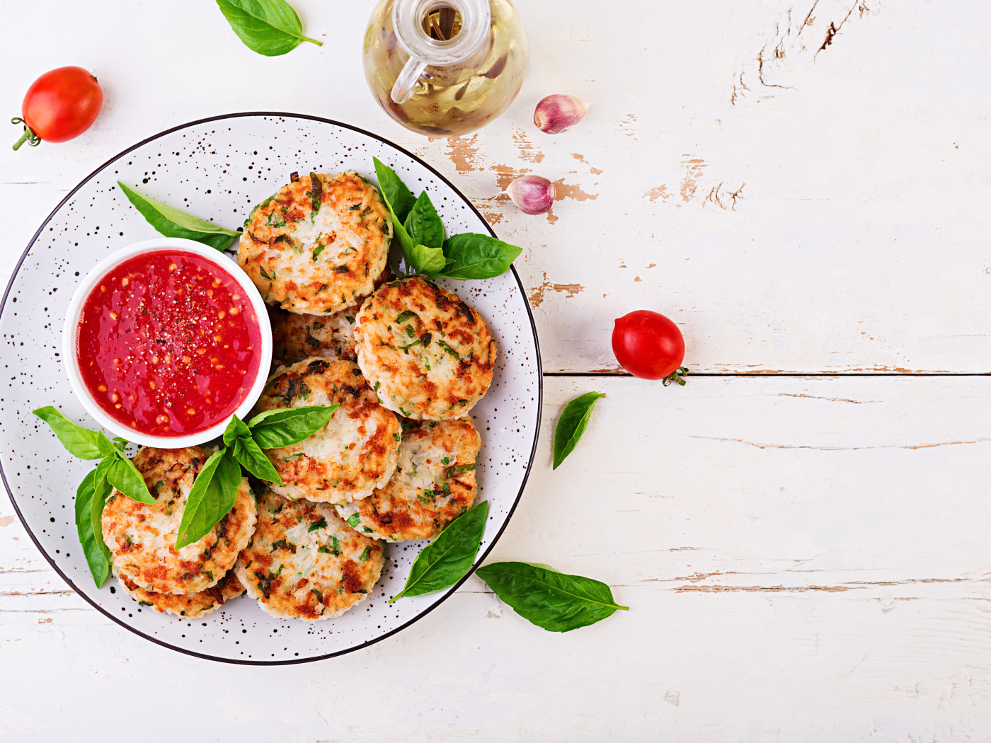 Куриные котлеты на большой белой тарелке  с соусом