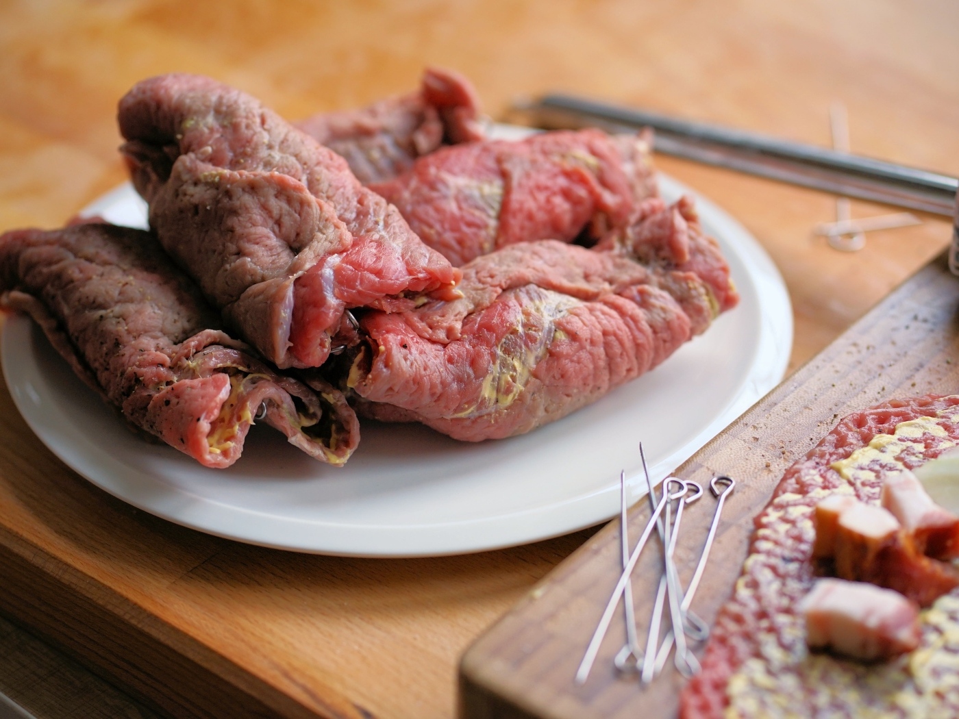 Рулетики из свинины на большой белой тарелке