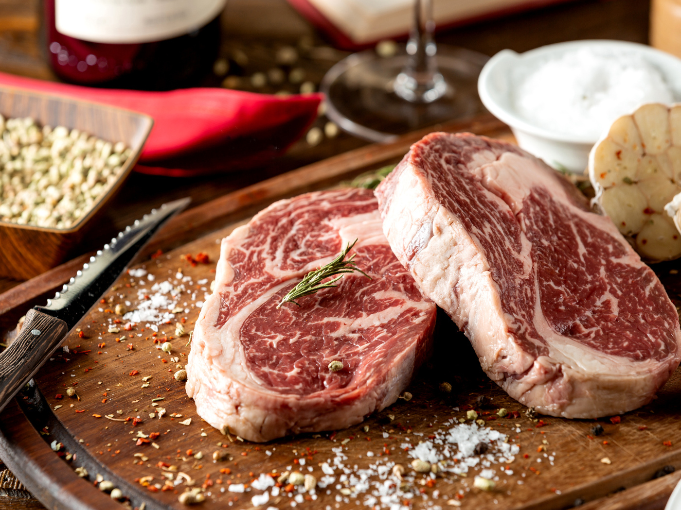 Два куска аппетитного стейка на столе со специями