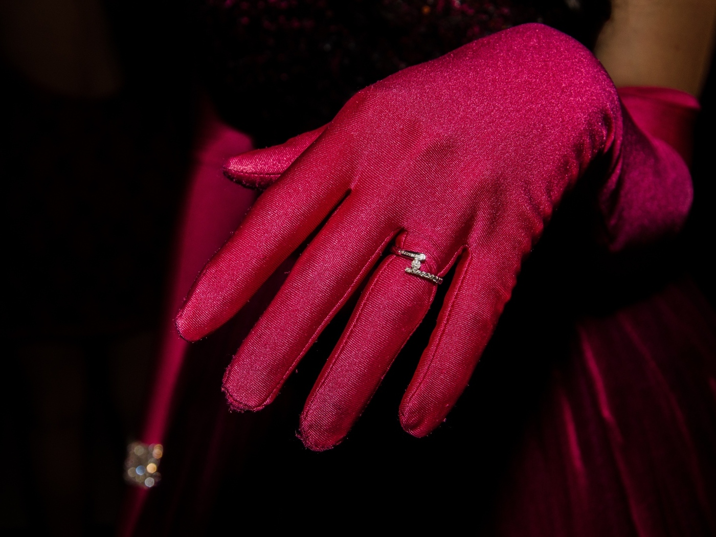 Женская рука с красной перчаткой и кольцом