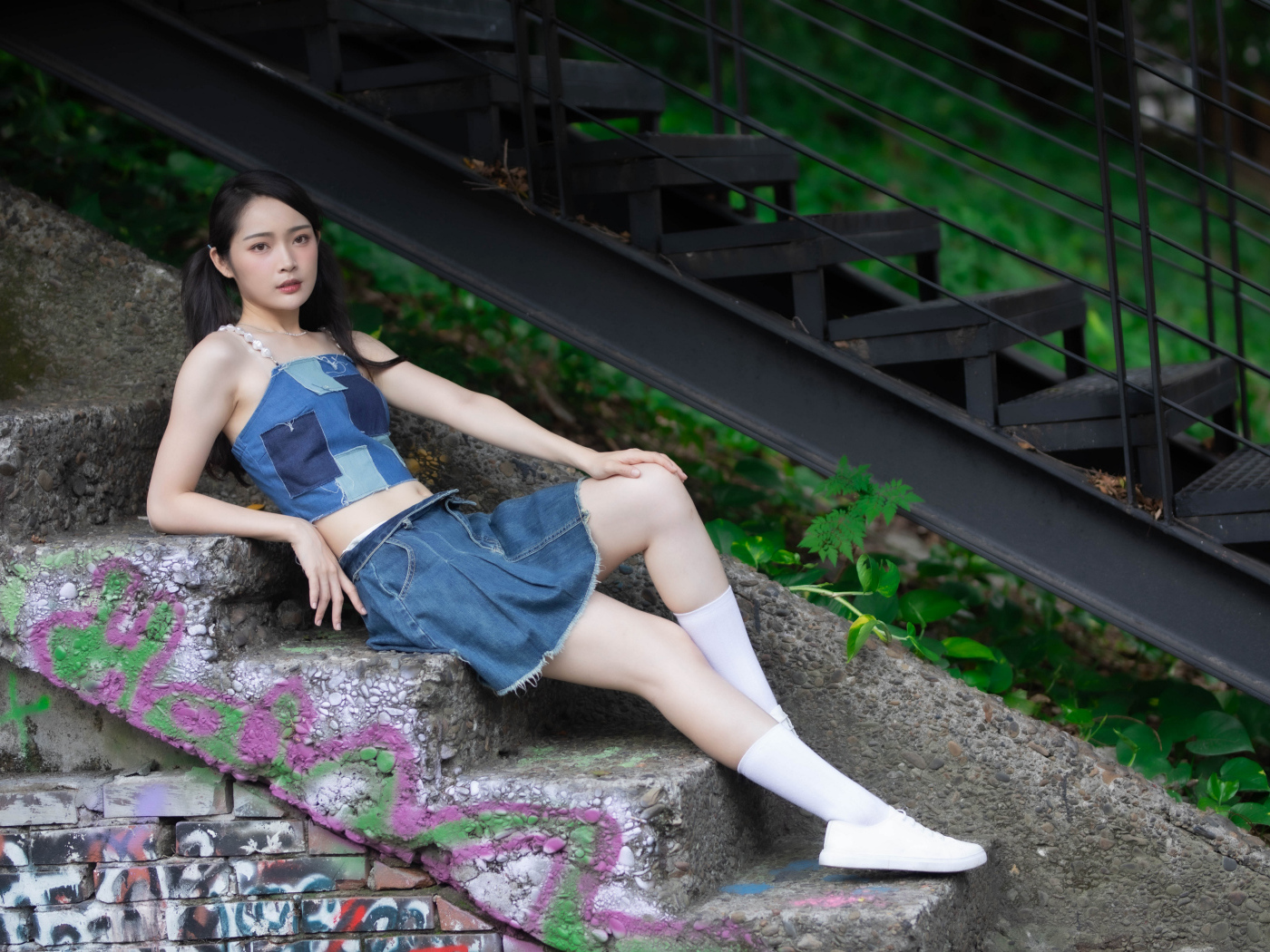 Девушка азиатка в юбке лежит на лестнице