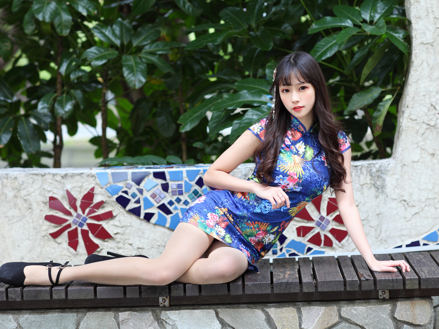 Красивая девушка азиатка в платье лежит на лавке