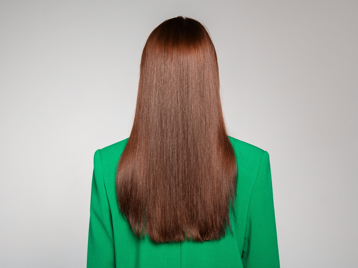 Красивые волосы девушки в зеленом пиджаке