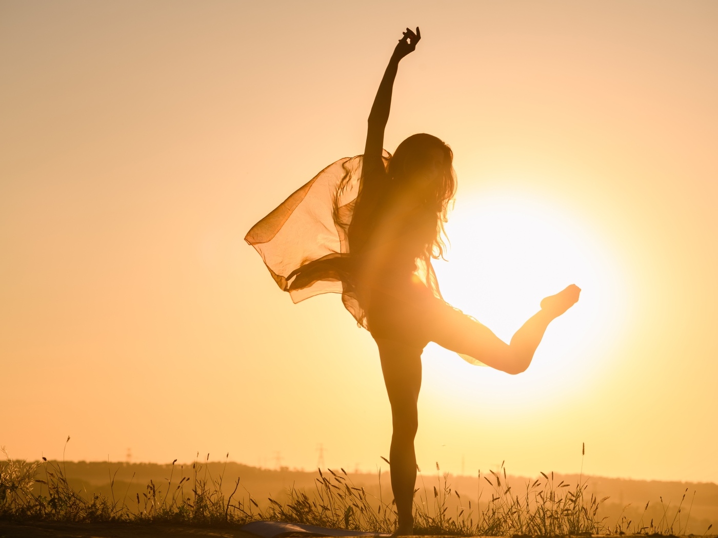 Девушка танцует в лучах солнца на закате