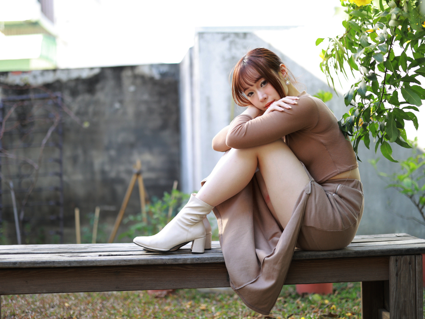 Скромная молодая азиатка сидит на лавке