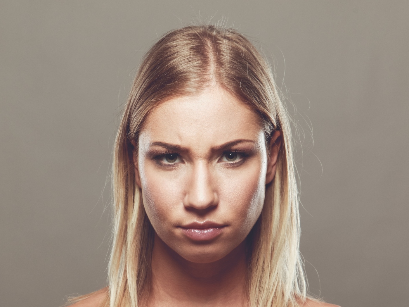 Серьезная девушка с короткой стрижкой на сером фоне