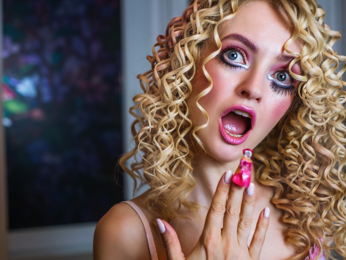 Удивленная девушка блондинка с макияжем куклы