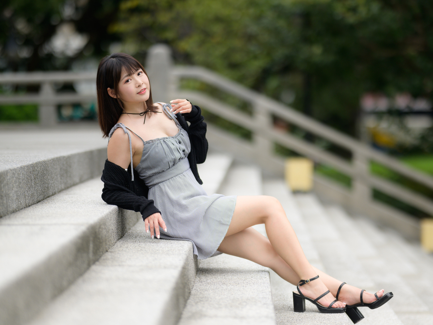 Молодая азиатка в платье лежит на ступеньках