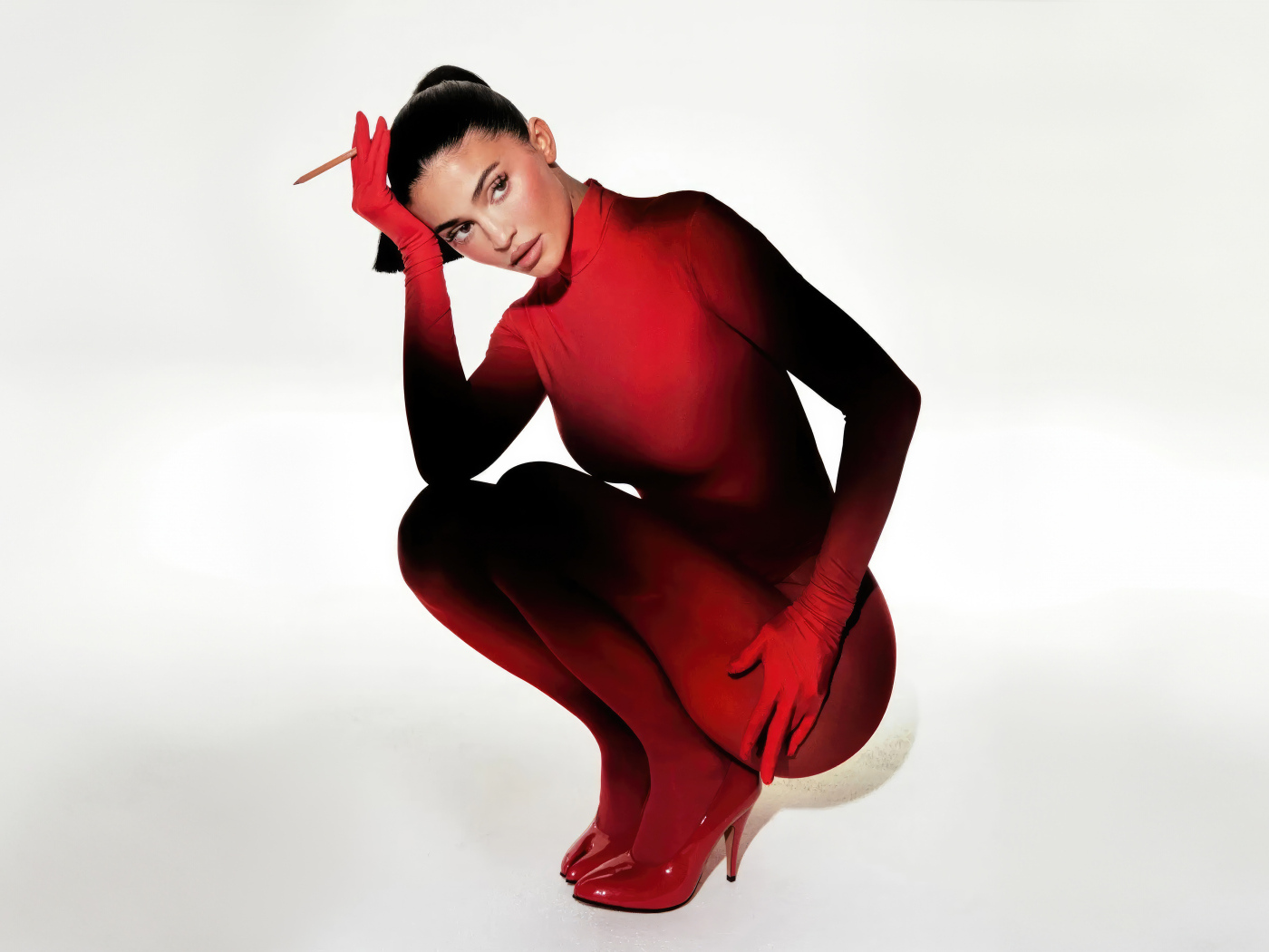 Красивая брюнетка модель Кайли Дженнер в красном костюме