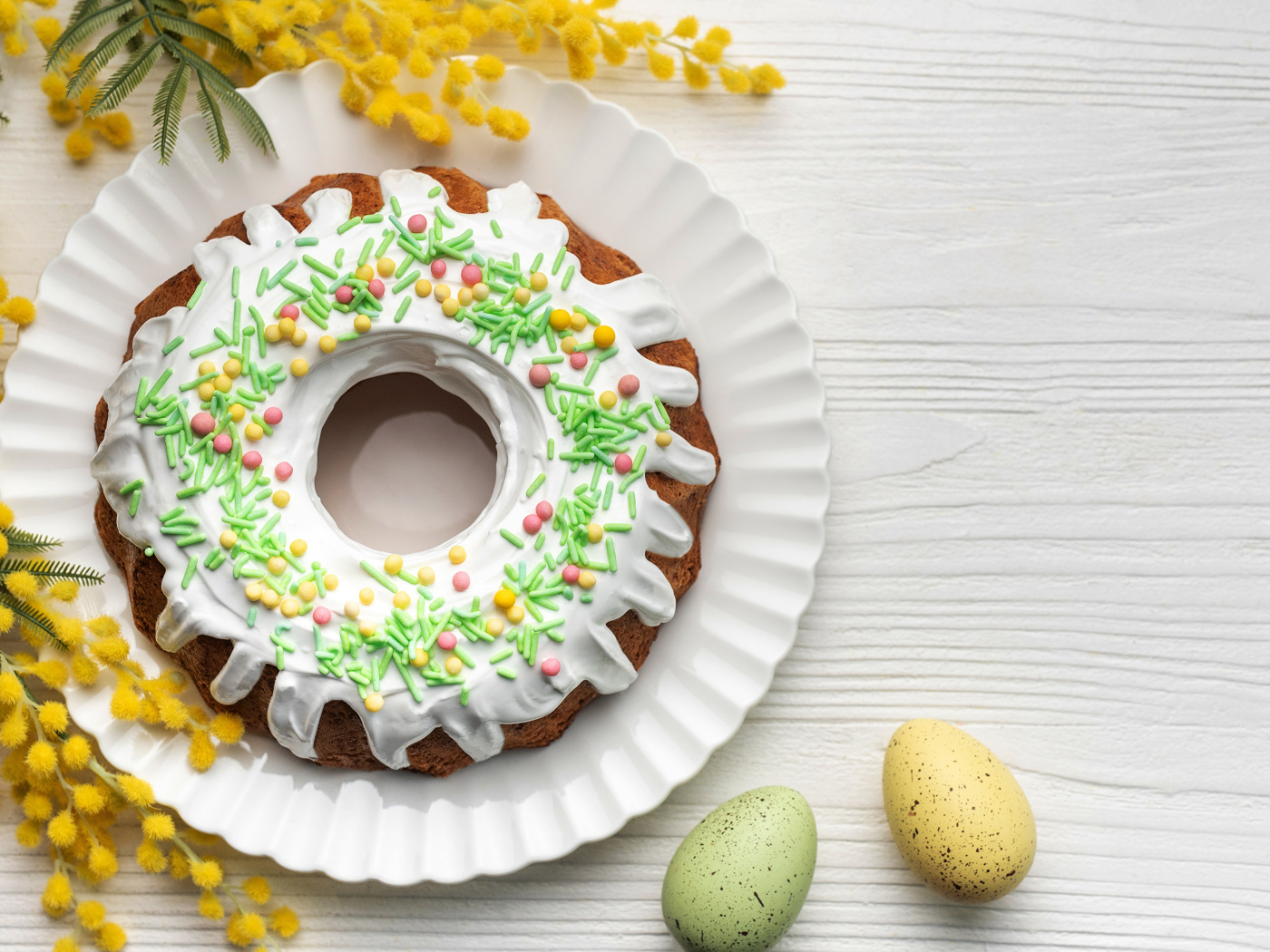Красивый пасхальный кулич с веткой мимозы и яйцами