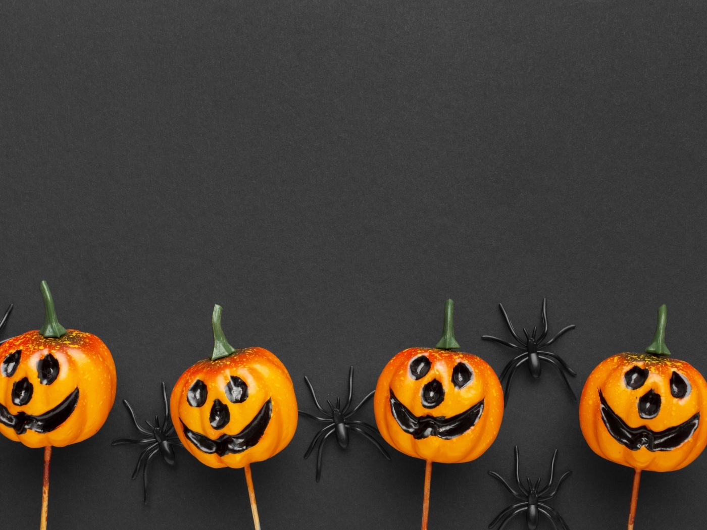 Тыквы с черными пауками на сером фоне на Хэллоуин
