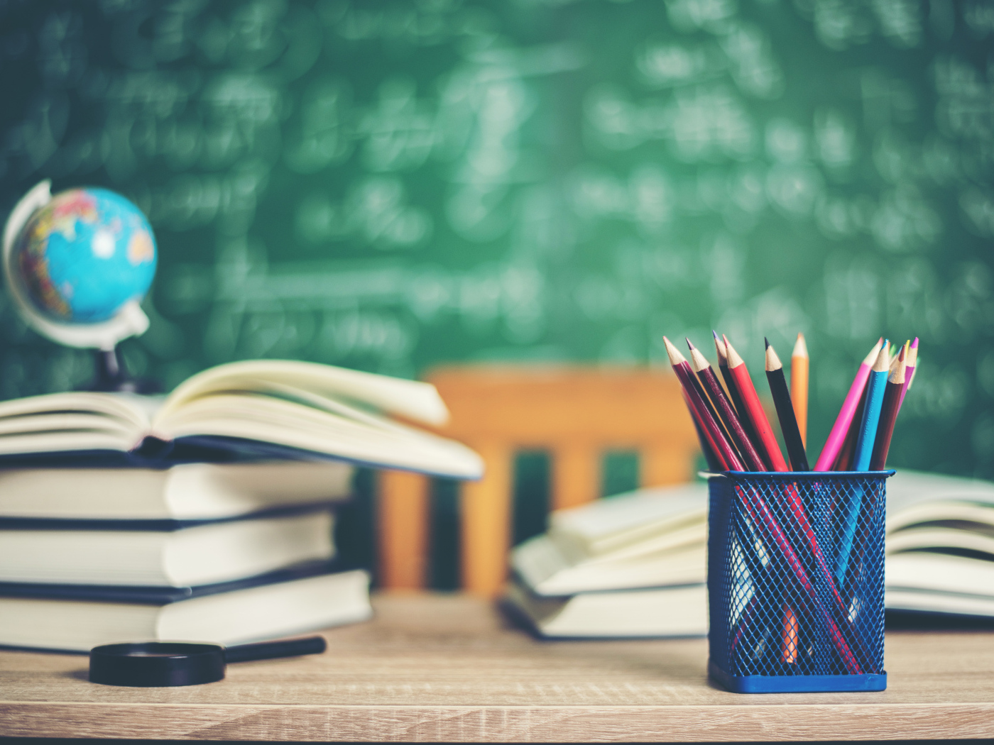 Карандаши на столе с книгами в школьном классе