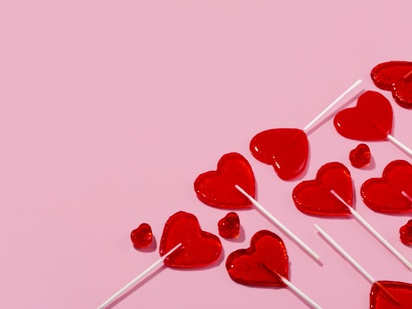 Леденцы в форме сердца на розовом фоне